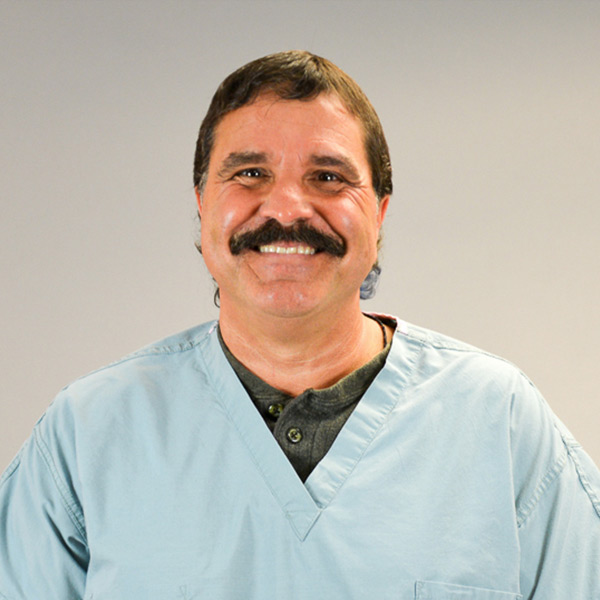 a headshot of Michael Cancilla in light blue medical scrubs