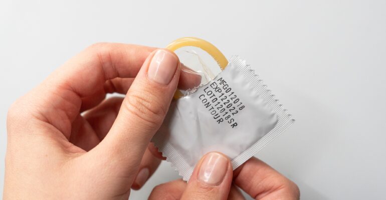 hands holding open condom
